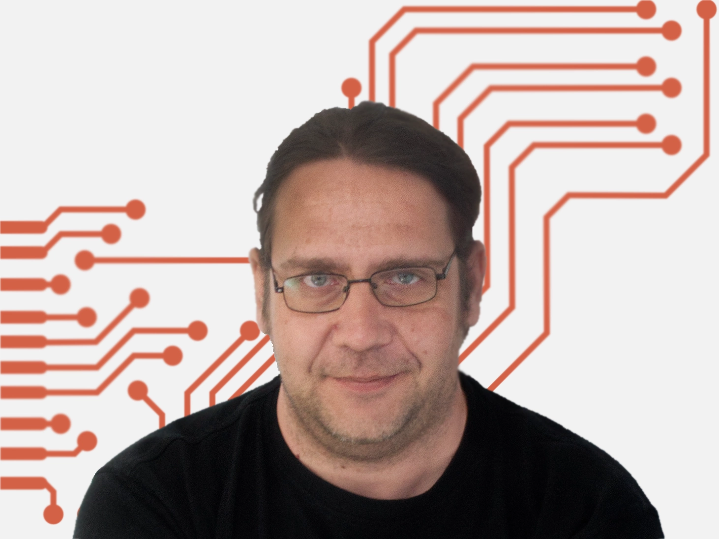 Mann mit Brille und langen Haaren, lächelnd in schwarzem T-Shirt